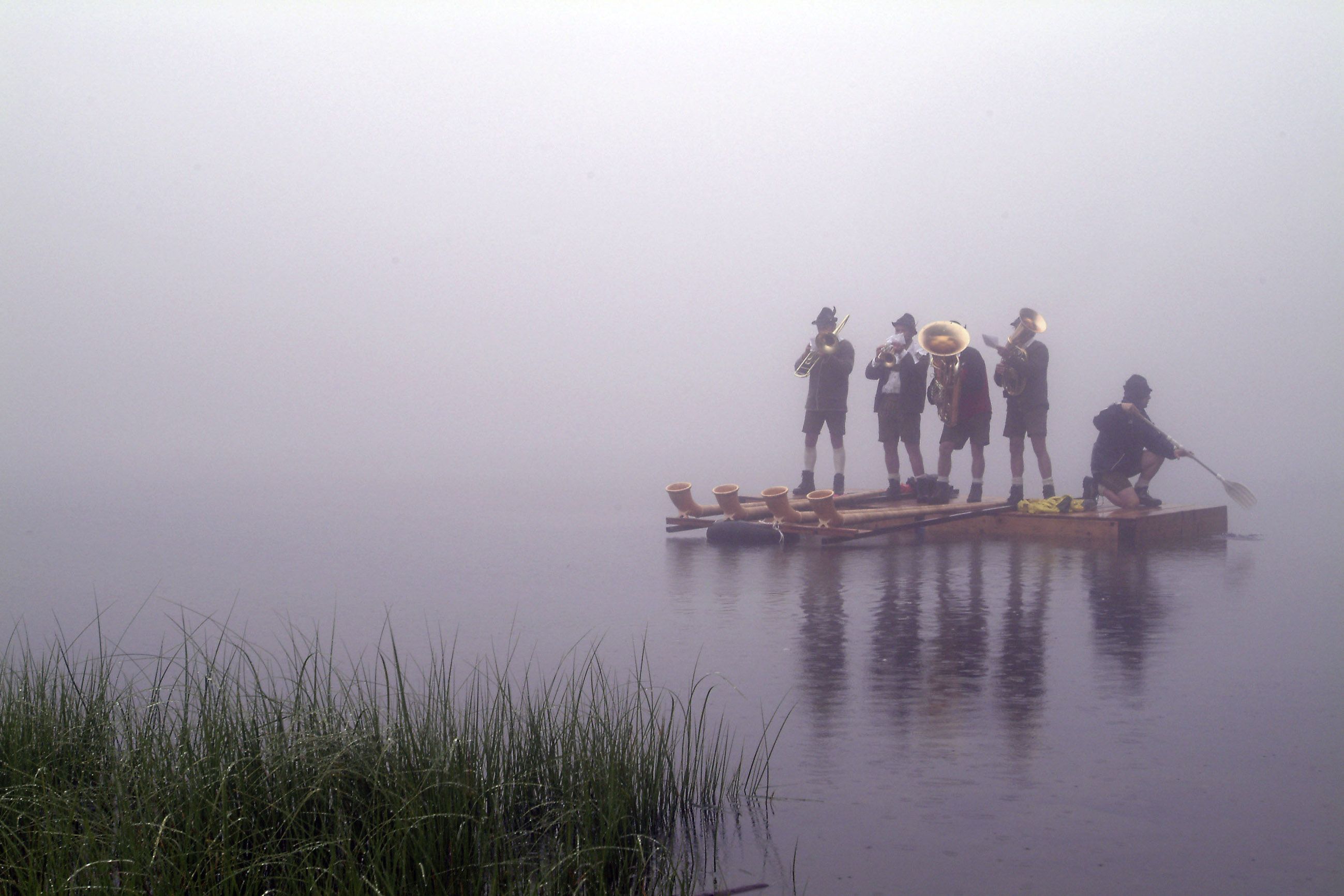 Blaskapelle auf einem Floß im Nebel.