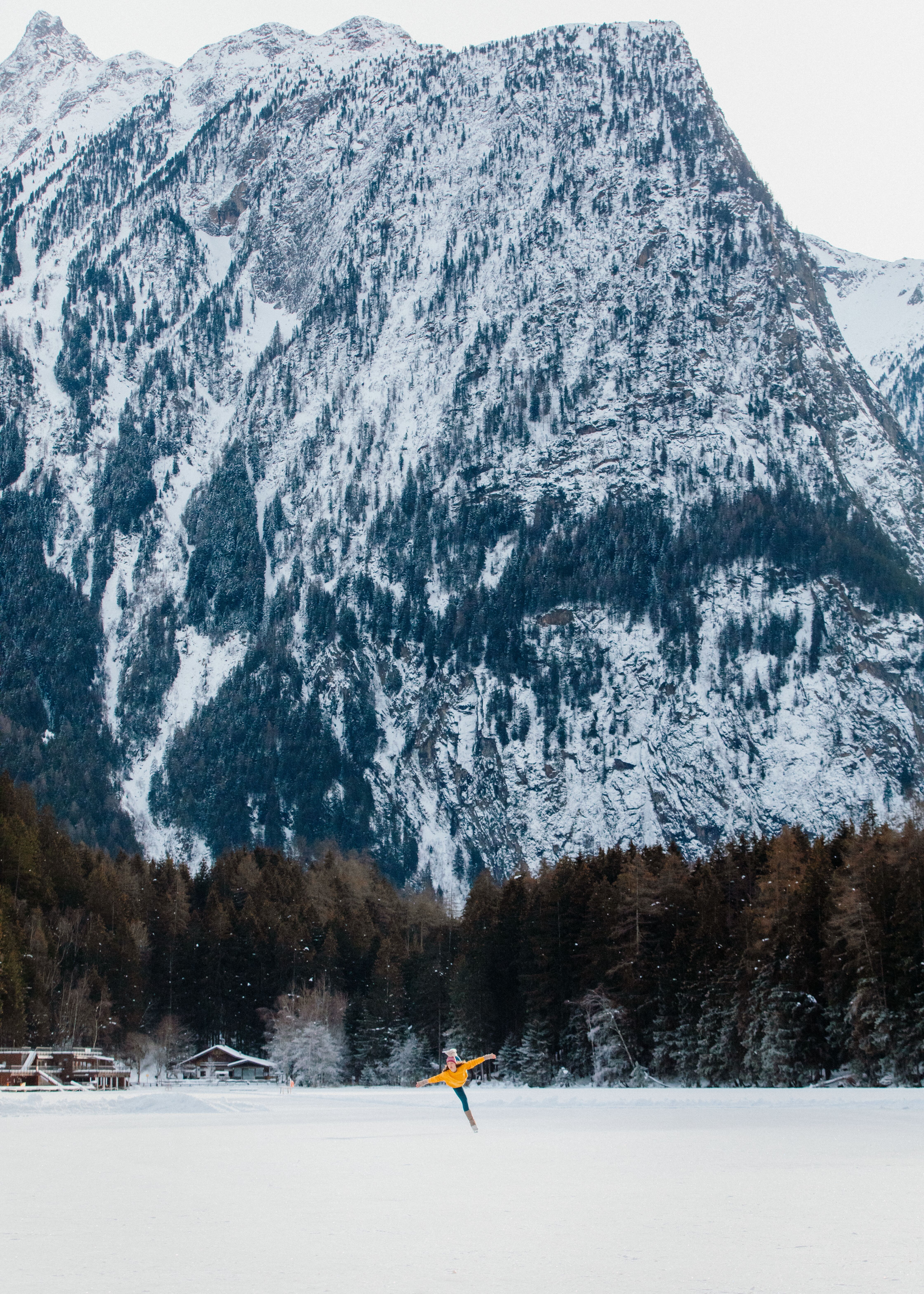 Eisläuferin läuft über den zugefrorenen Piburger See. Im Hintergrund ragt das 1.047 Meter hohe Seejöchl empor.